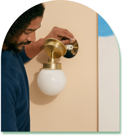 guy installing light sconce