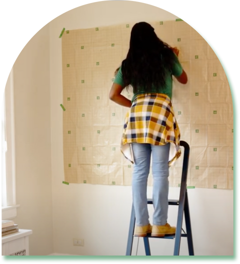 Woman hanging gallery wall using character gallery wall kit