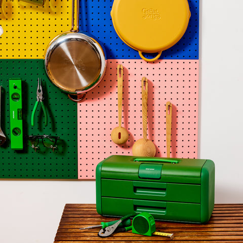 Image of pegboards mounted on wall with cookware and toolbox